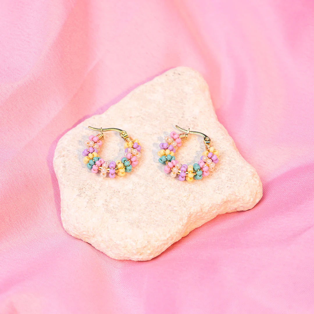 Handmade mini hoop earrings embellished with colorful beads and featuring bronze stud accents and gold plating.