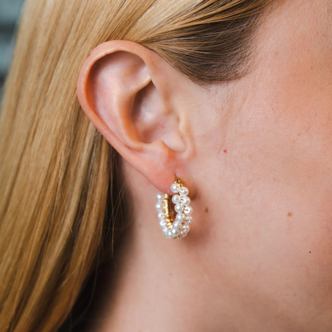 Handmade mini hoop earrings embellished with colorful beads and featuring bronze stud accents and gold plating.